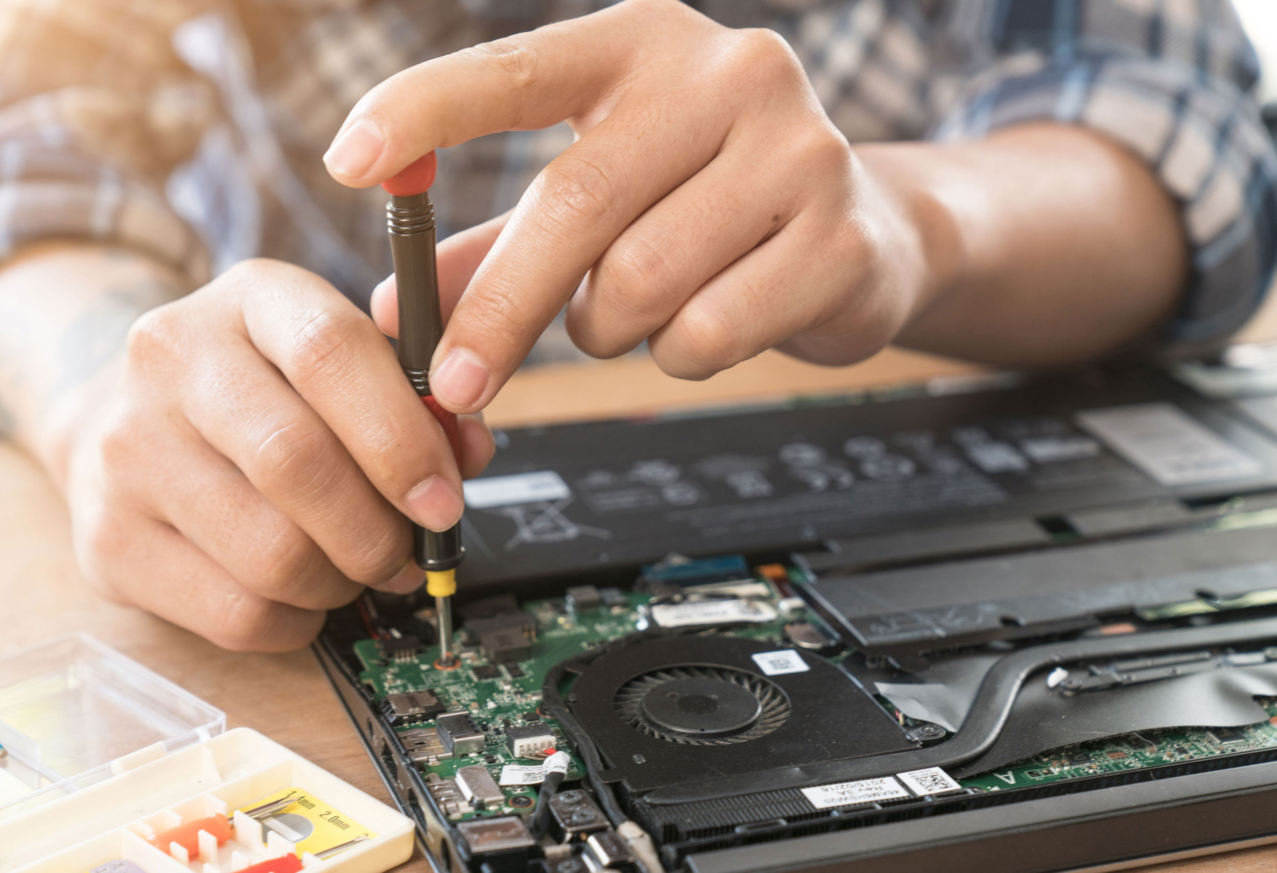 Technician repairing the internal components of a laptop